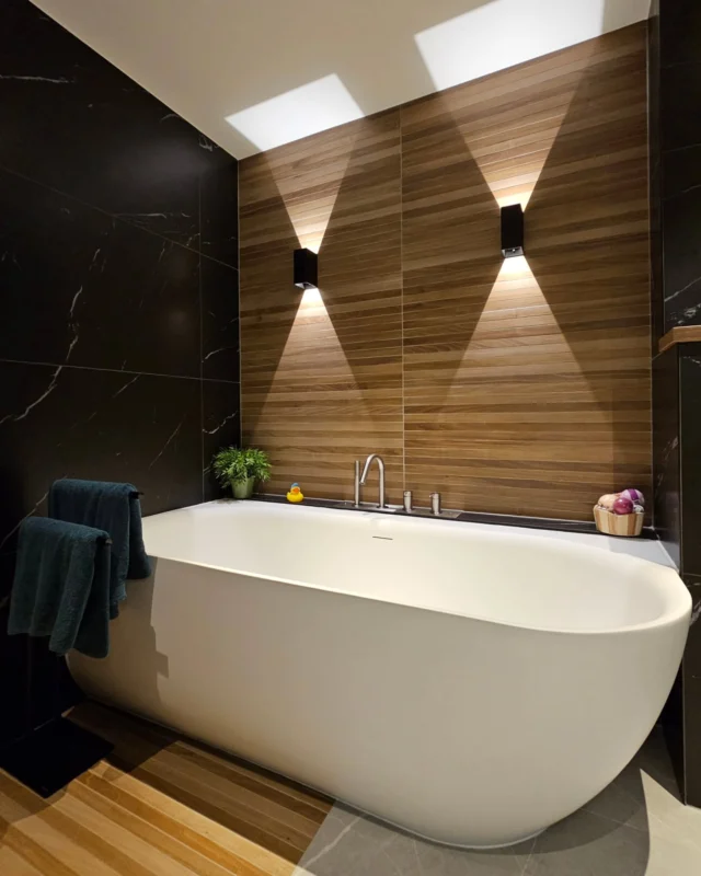 In weelde baderen. Dat is wat in deze badkamer kan. Voor deze familie uit Zwammerdam heb ik naast de begane grond ook de badkamer herontworpen. Met heerlijk bad, ruime regendouche en genoeg opbergruimte voor de 3 vrouwen in dit gezin.

'Maar Elroy, waar is je befaamde kleur?'
Echte kleur mag hier dan niet naar voren komen, een heerlijke badkamer is het wel. En zeker naar de wens van de klant. Die had hier weinig kleur als inspiratie.
Wel laat ik iedereen genieten van de materiaalkeuze. De look en feel van natuurlijke materialen. De smalle houtlook tegel die de natte zones met elkaar verbindt. Alsof je staat te douchen op Bali.

Als extra touch de wandlampen. Om net even wat meer luxe sfeer te krijgen dan alleen spots in het plafond. Zeker met hoe het licht zijn werk doet, is het een eyecatcher.
Dit in samenwerking met @deknikker.keukens.badkamers uit Alphen a/d Rijn.

Badkamers komen regelmatig voor in mijn werkzaamheden. Hoe past alles in een kleine ruimte? Is een bad wel echt handig? Wil je het toilet in de ruimte of los? Allemaal vragen die langskomen.

Wil je ook genieten van een heerlijke badkamer? Dan is het tijd voor een interieurontwerp van Elroy. Stuur mij een PM en we maken een afspraak!